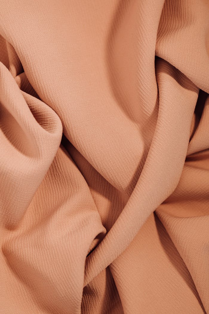 services-01 A detailed view of beige fabric emphasizing texture and ripples, suitable for backgrounds or textiles.