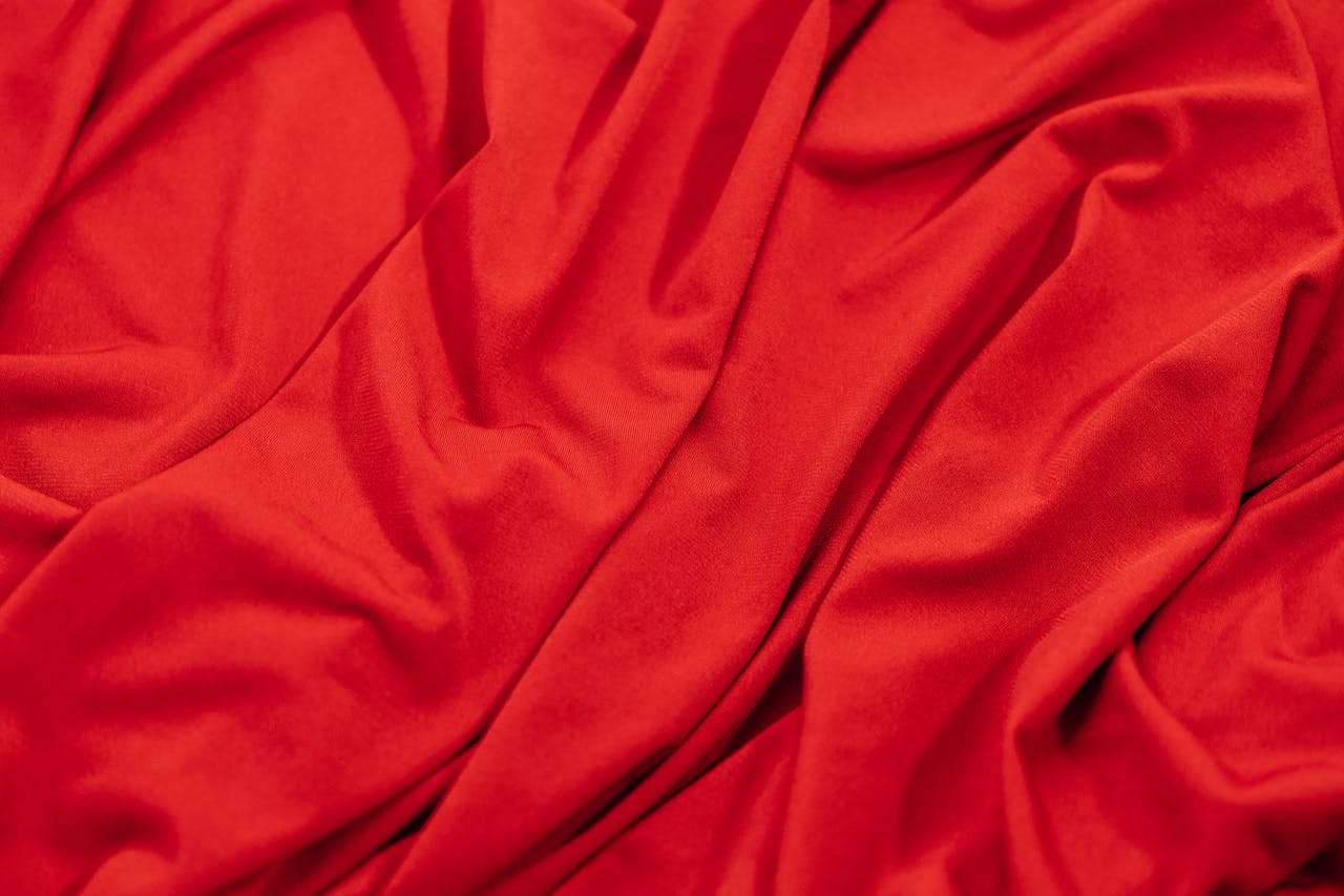 why-choose-us Close-up of smooth red fabric with elegant drapes and folds, showcasing its vibrant texture.