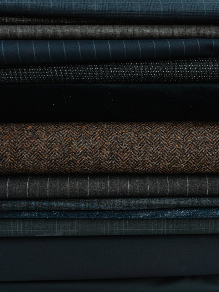 who-we-are Close-up of stacked textured fabrics in diverse materials and patterns.