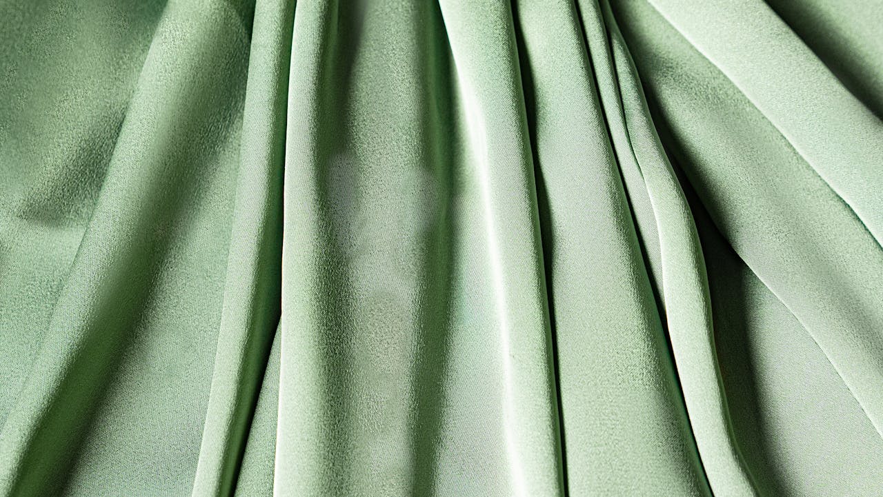 services-02 Close-up of green fabric with a textured and pleated design, ideal for fashion or design concepts.