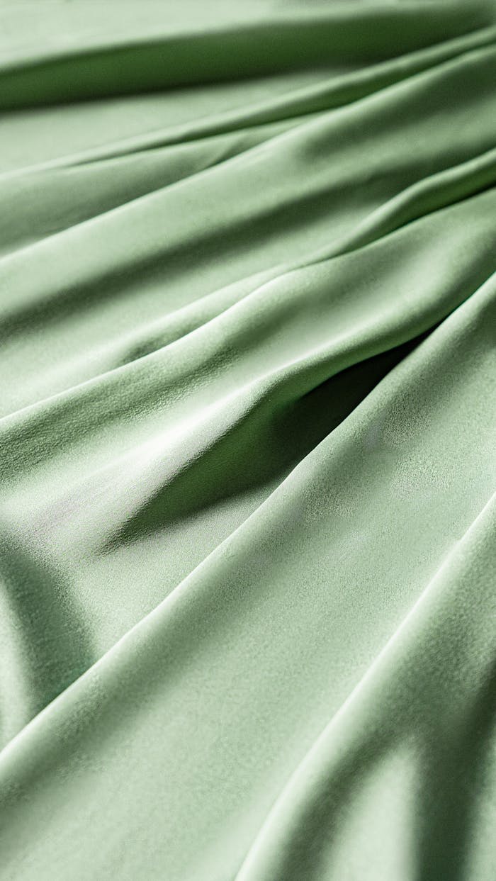 services-03 Elegant and smooth green fabric texture with gentle drapery folds in a vertical shot.